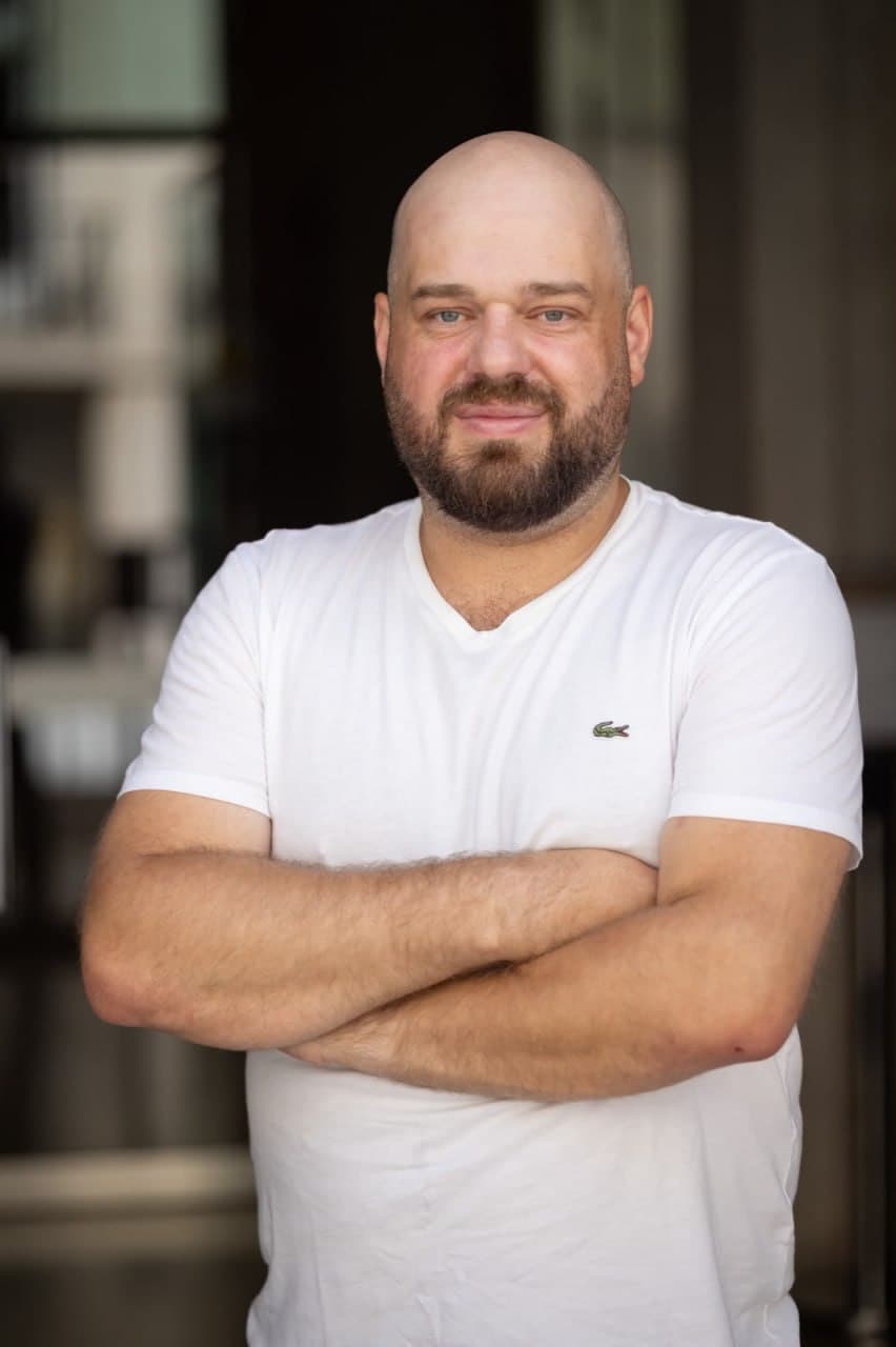Christian Rückert blickt mit verschränkten Armen in die Kamera